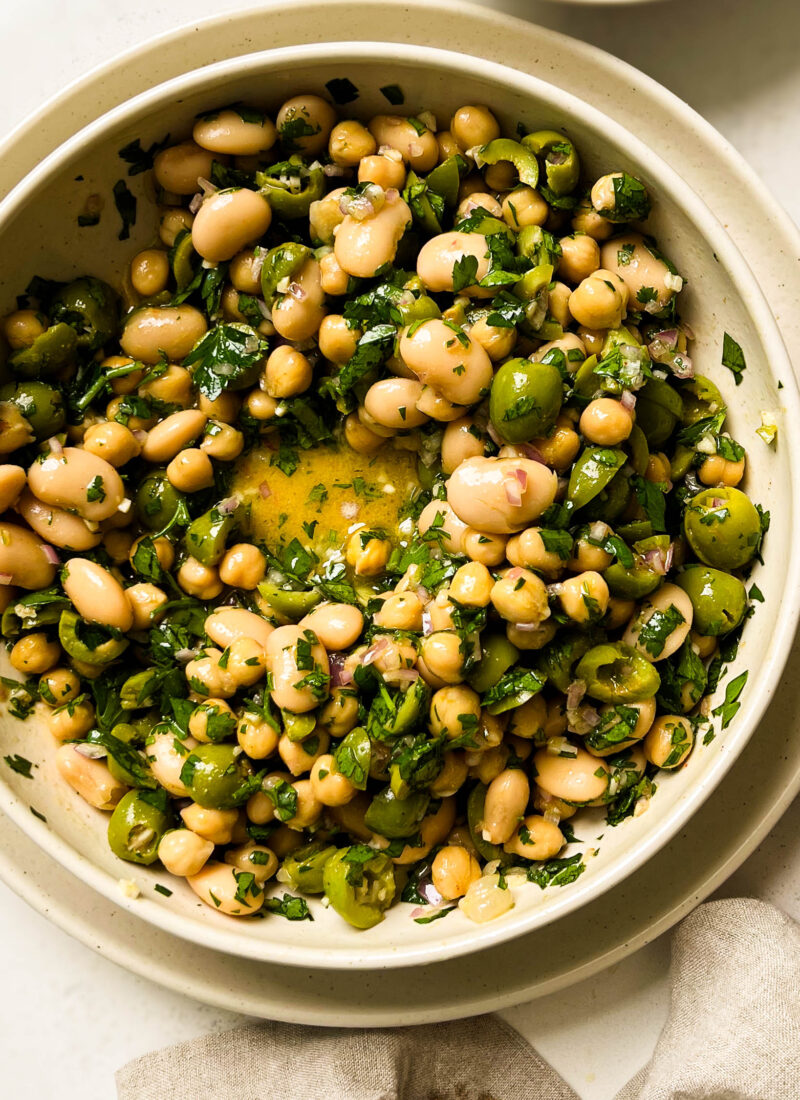 green olive bean salad in a beige bowl