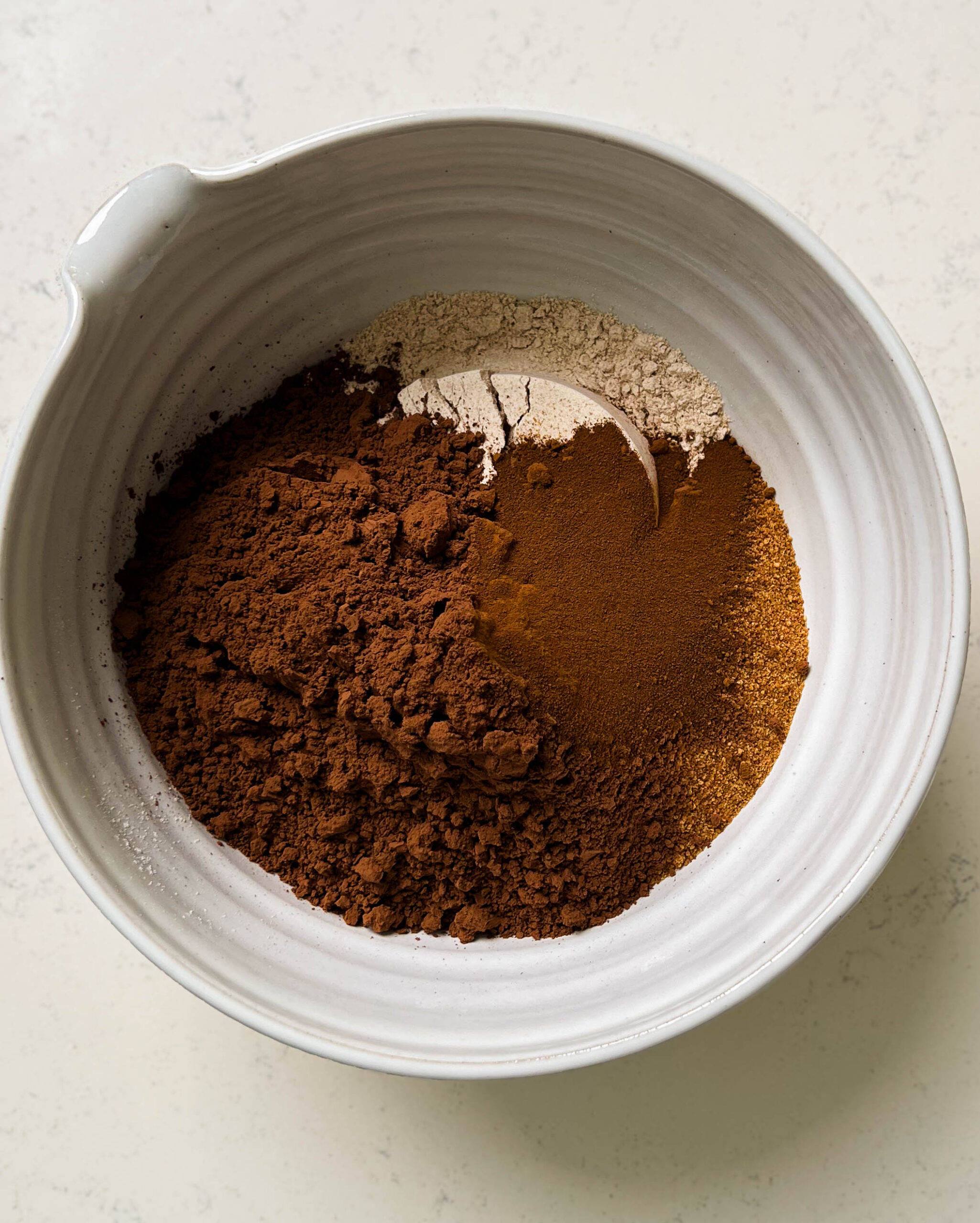 big white bowl of coconut sugar, cocoa powder, and spelt flour