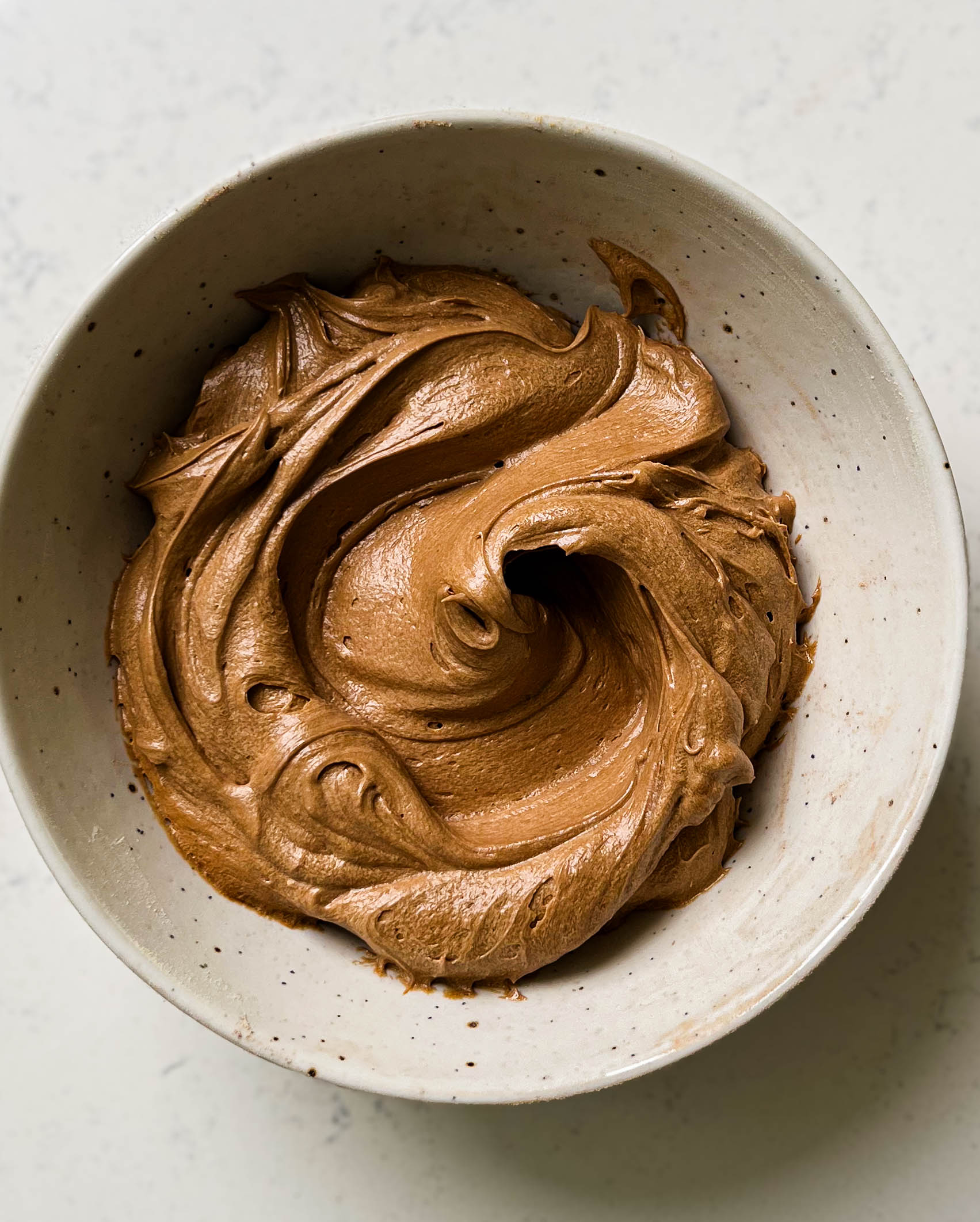 mocha frosting in a speckled bowl