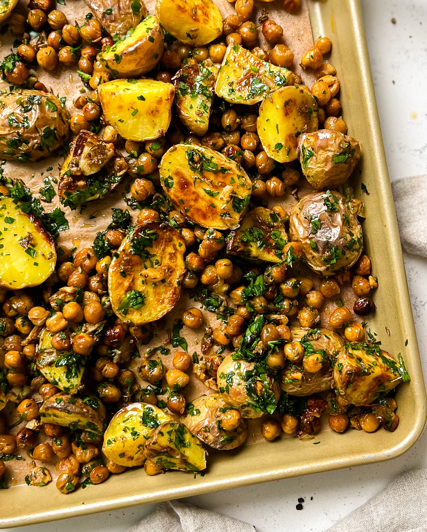 roasted potatoes and chickpeas on a gold pan