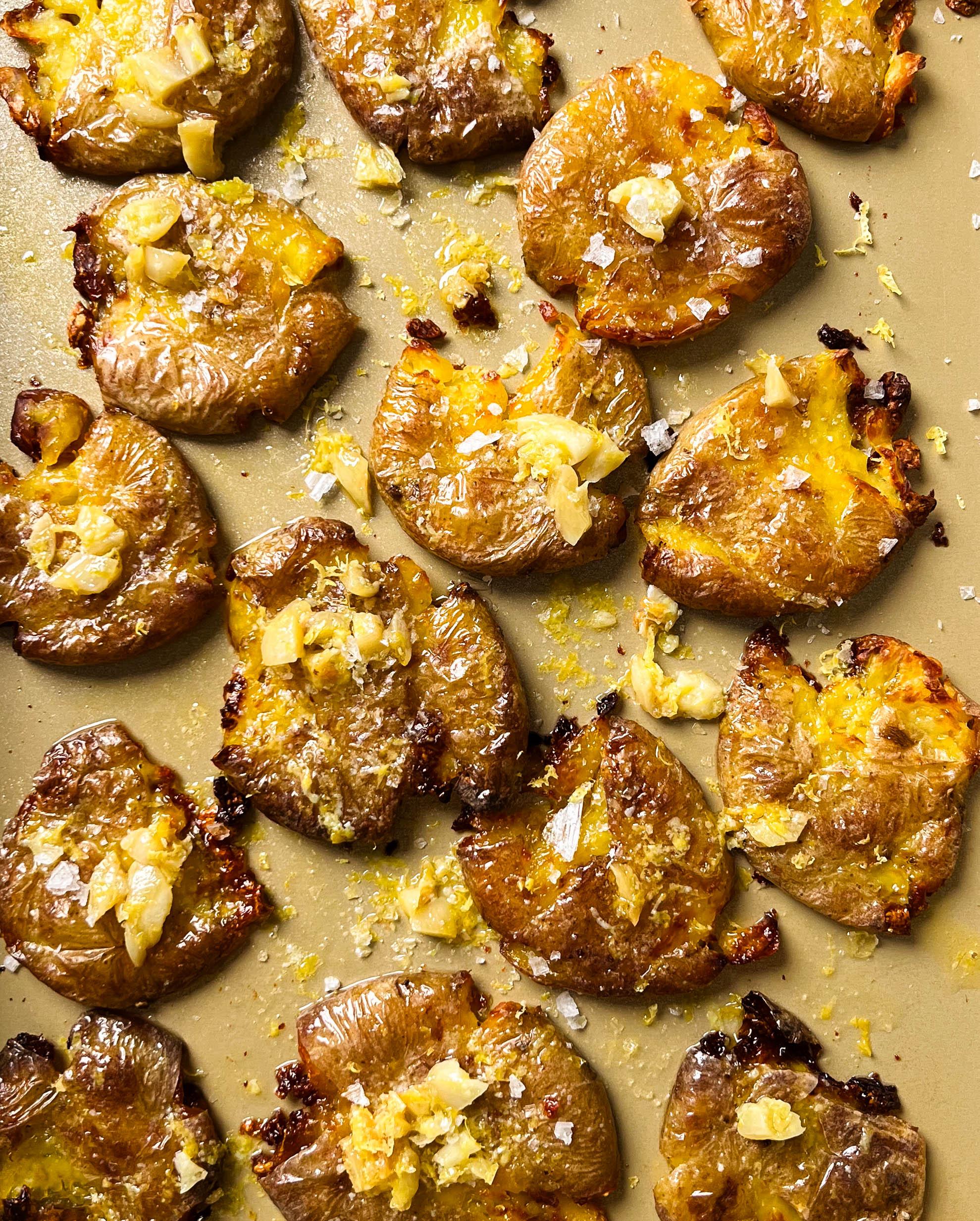 crispy smashed potatoes on a gold baking sheet