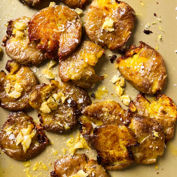 crispy smashed potatoes on a gold baking sheet