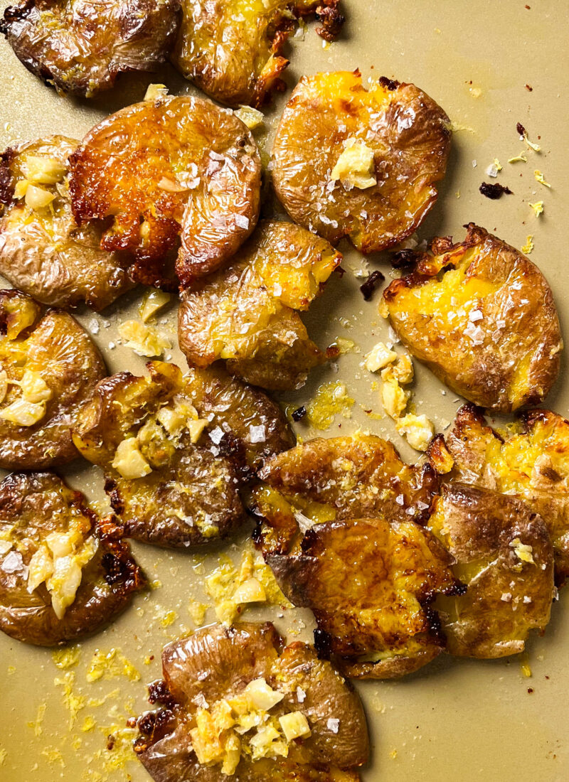 crispy smashed potatoes on a gold baking sheet