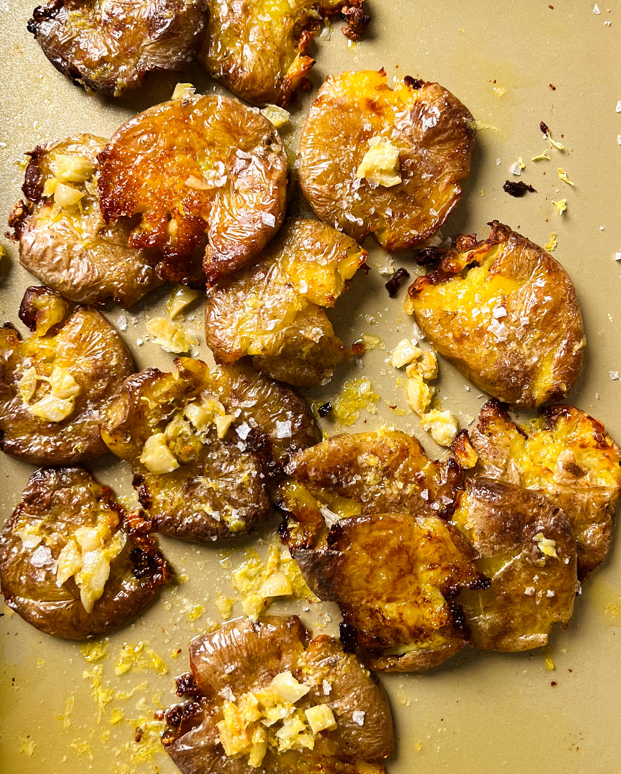 crispy smashed potatoes on a gold baking sheet