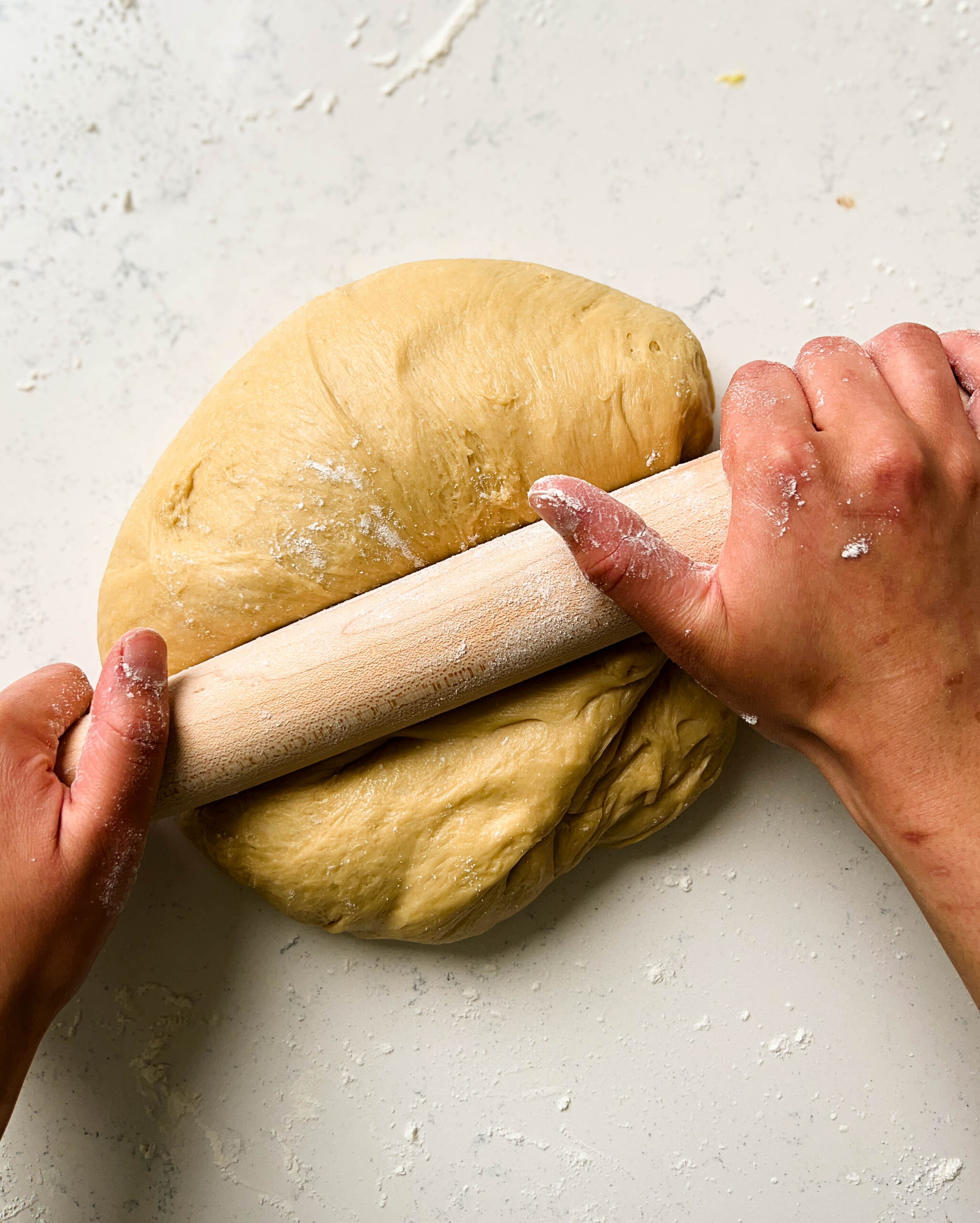 rolling dough with a wooden rolling pin