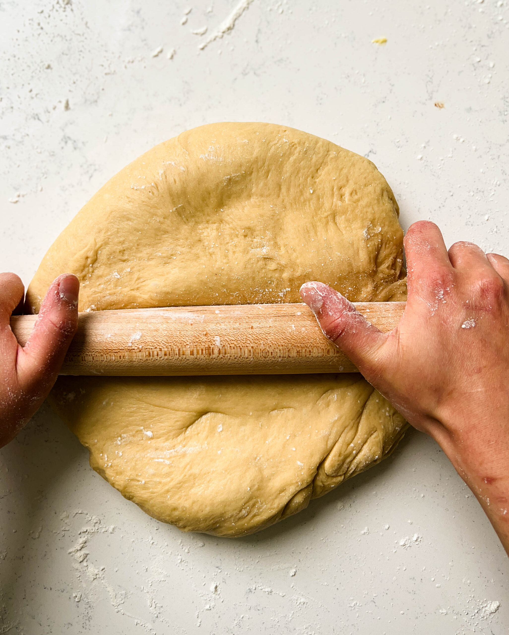 rolling dough with a wooden rolling pin