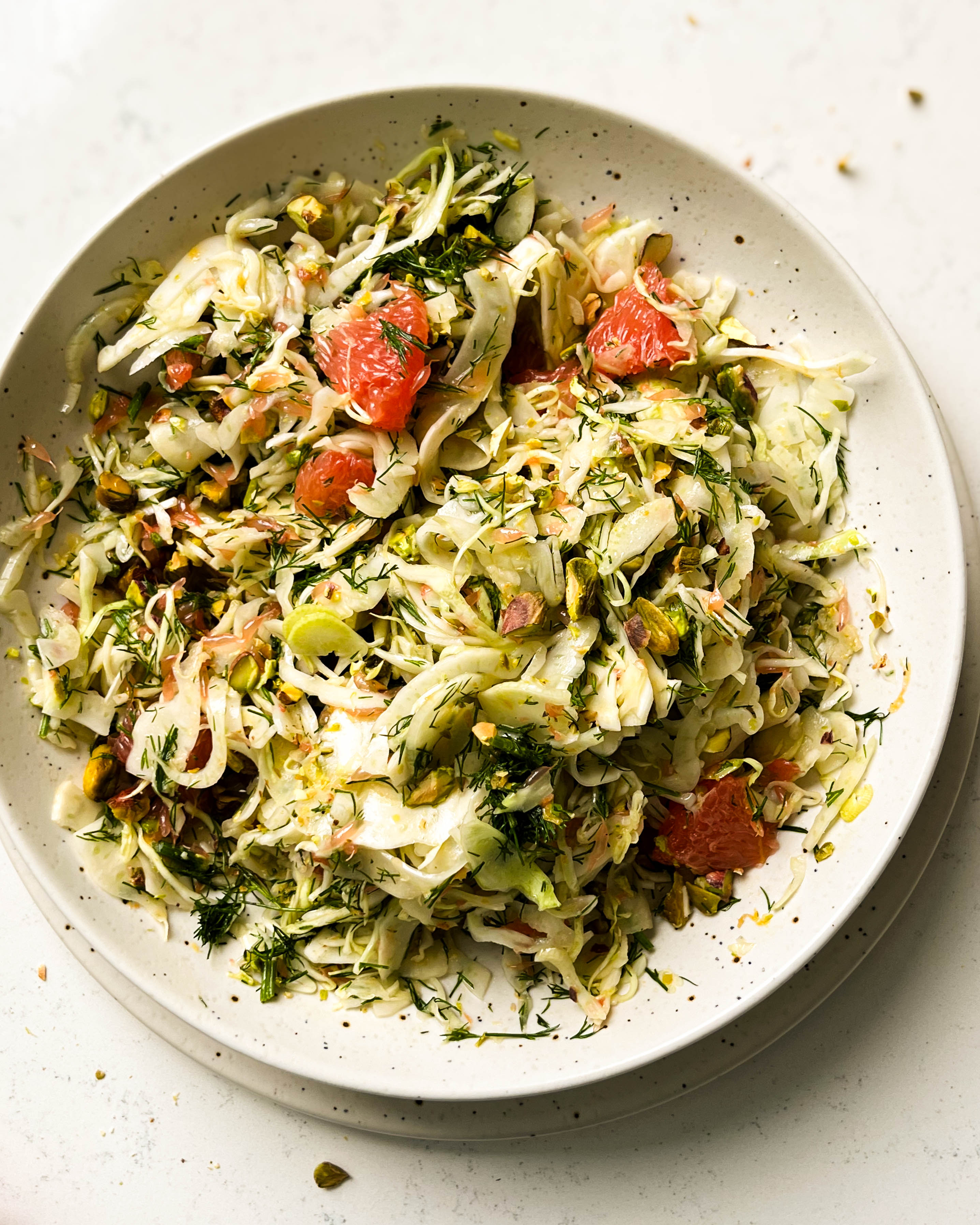 shaved fennel salad in a speckled white bowl