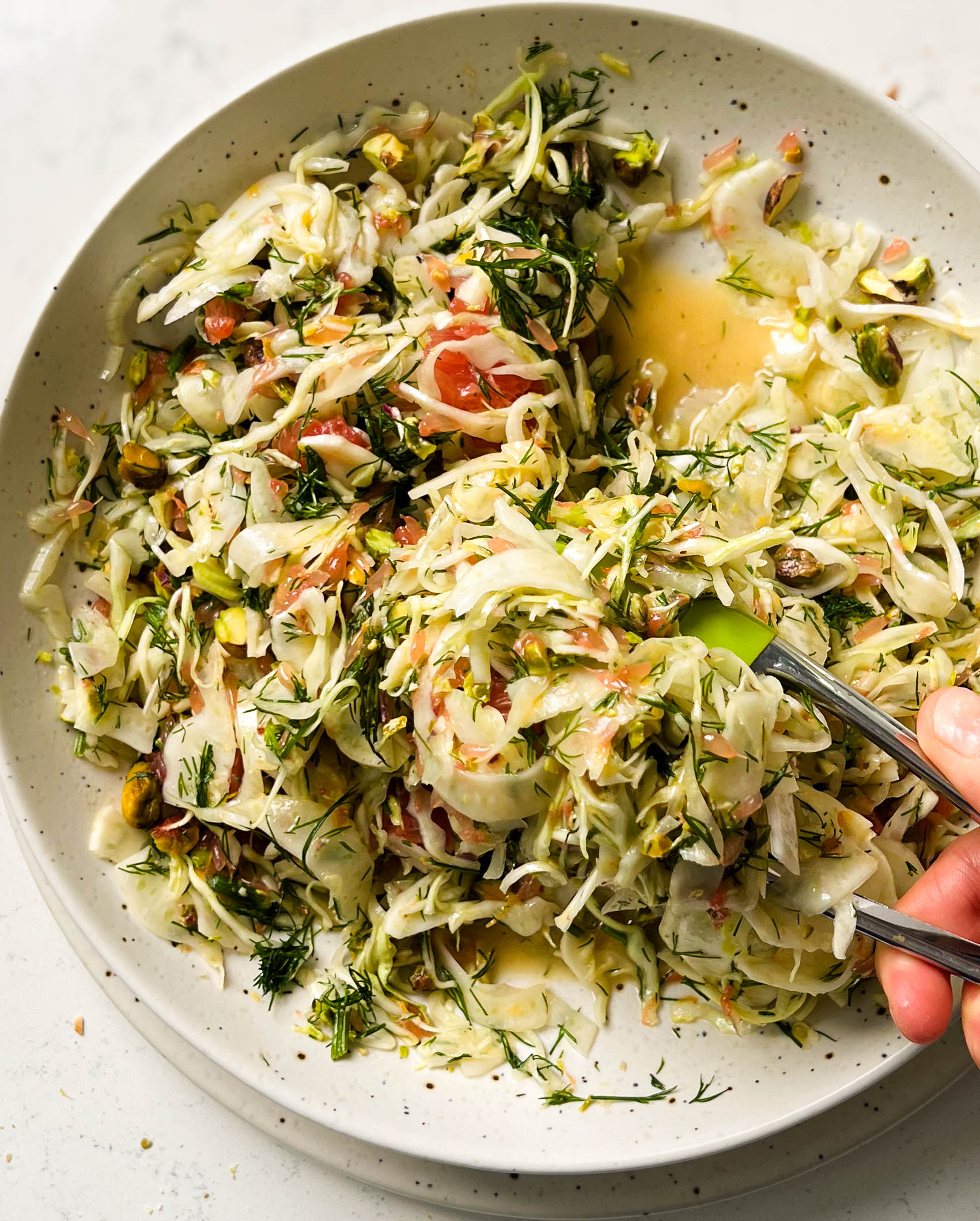 shaved fennel salad in a speckled white bowl