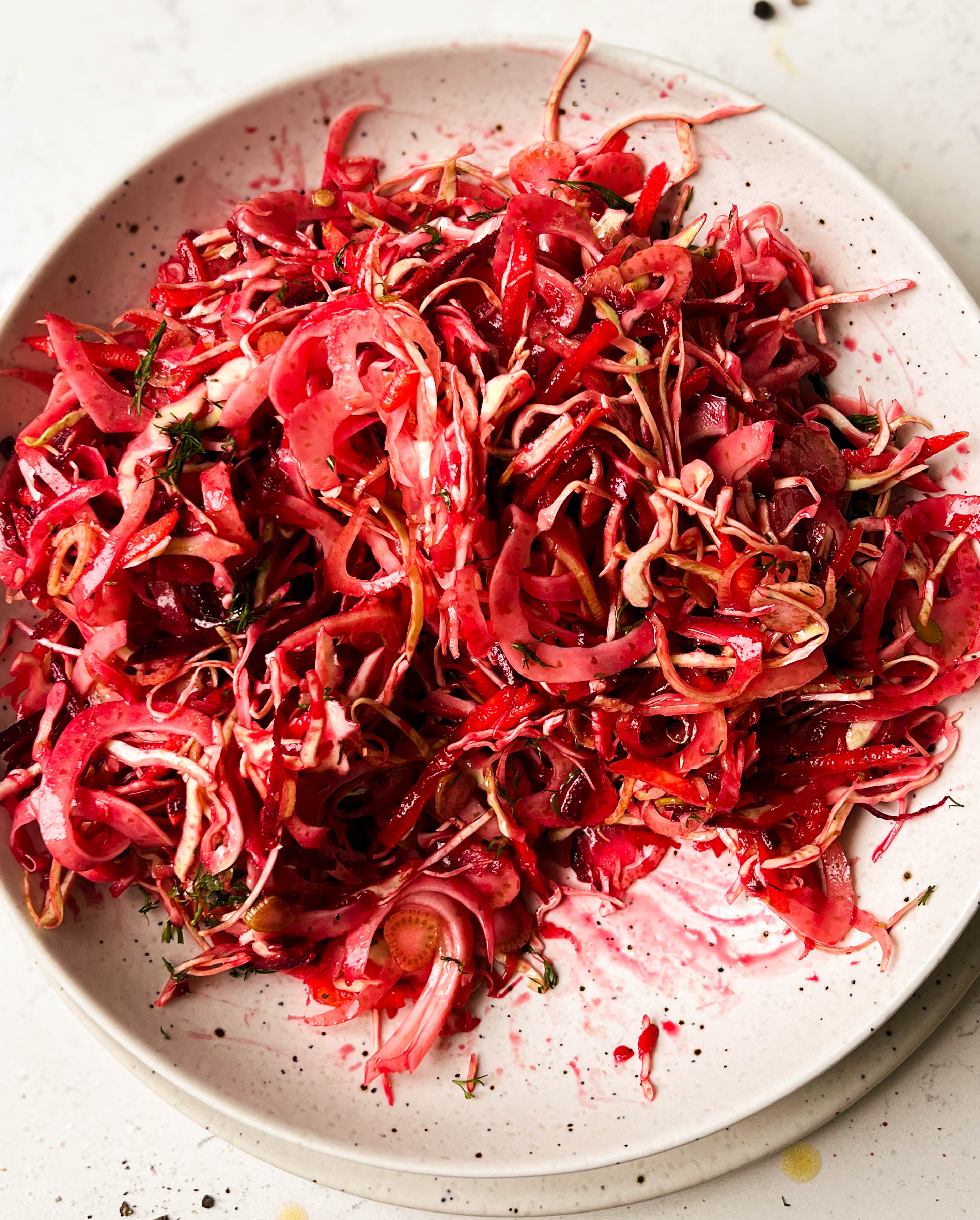 pink slaw salad in a white bowl