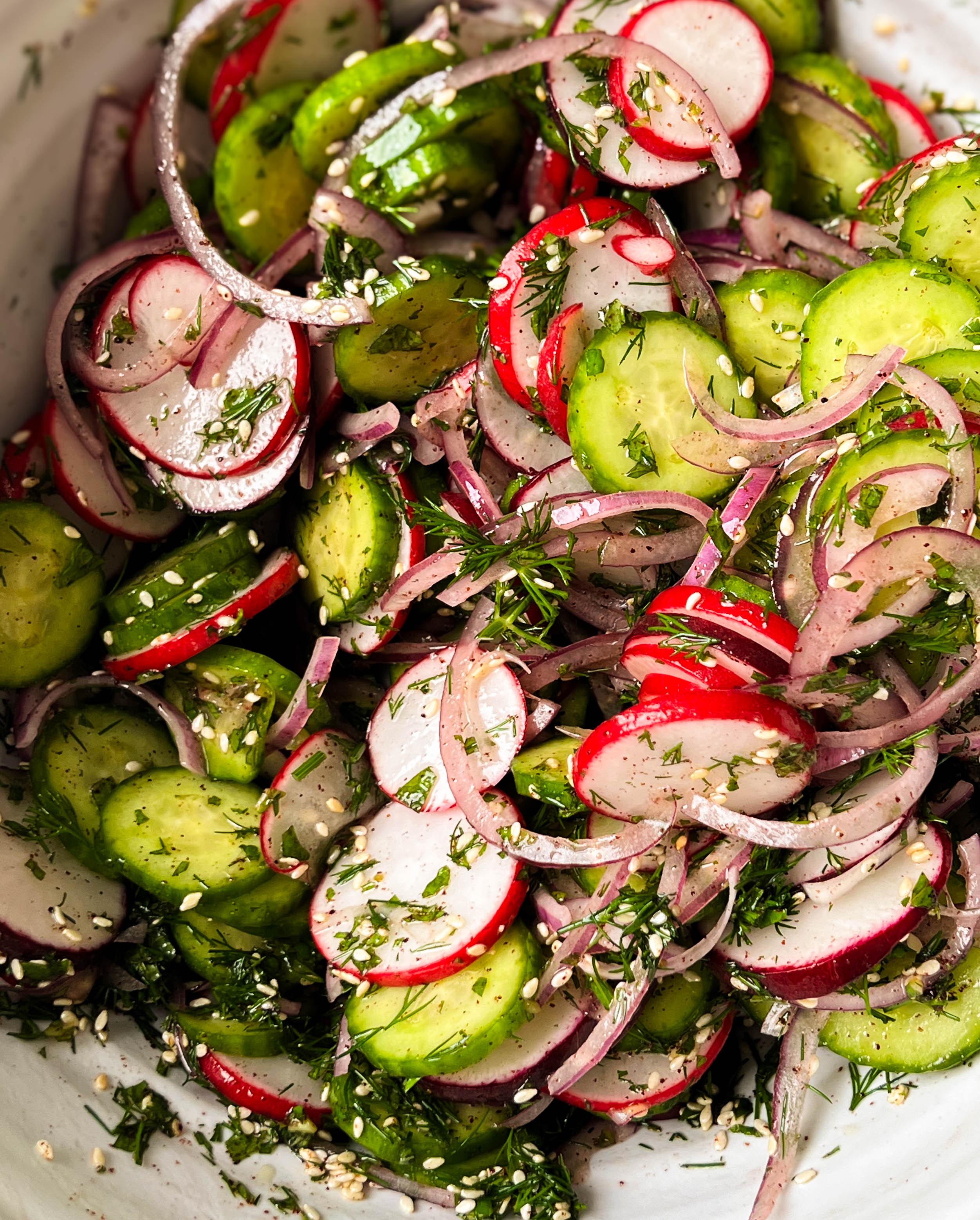 sumac cucumber radish salad in a white bowl