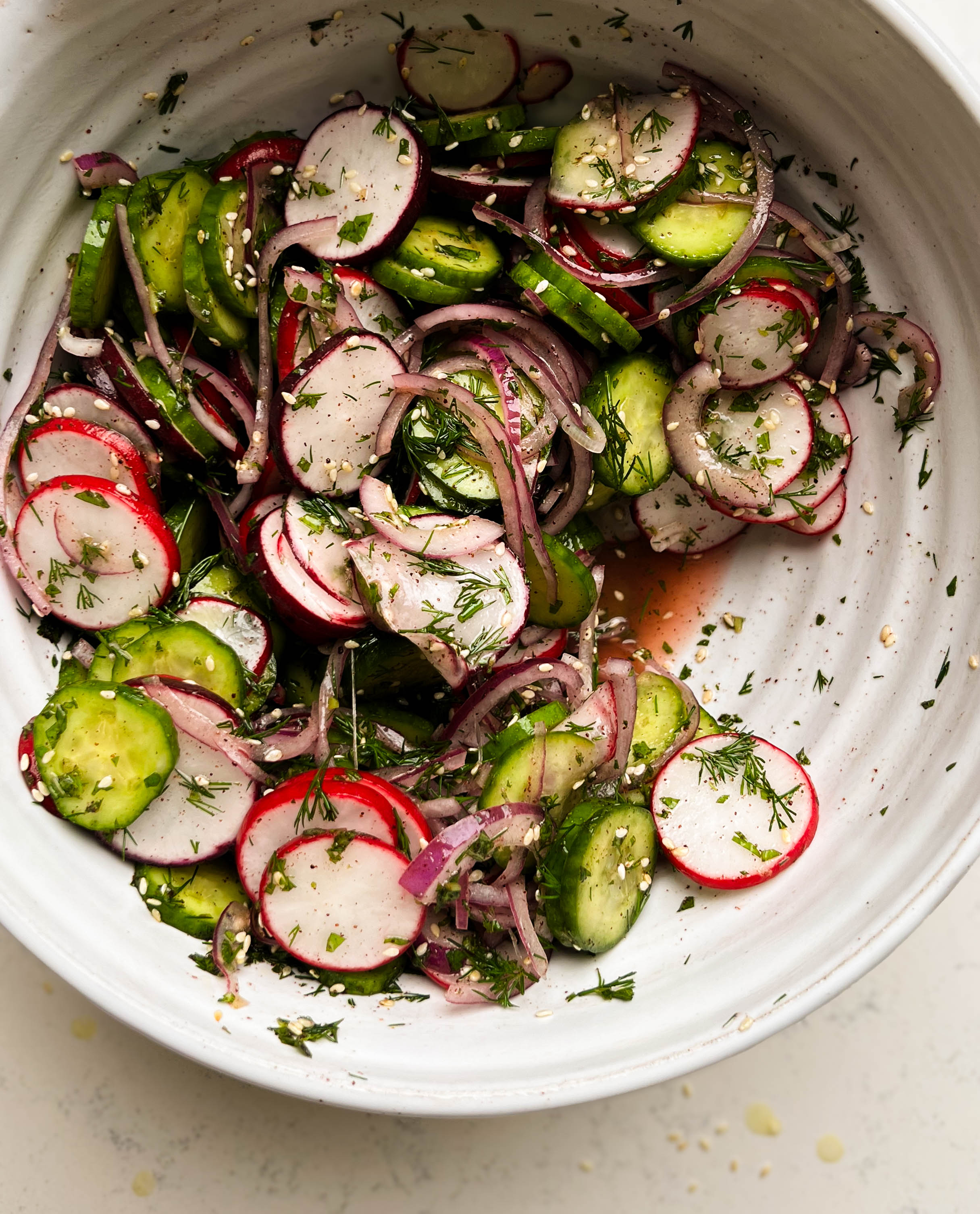 sumac cucumber radish salad in a white bowl