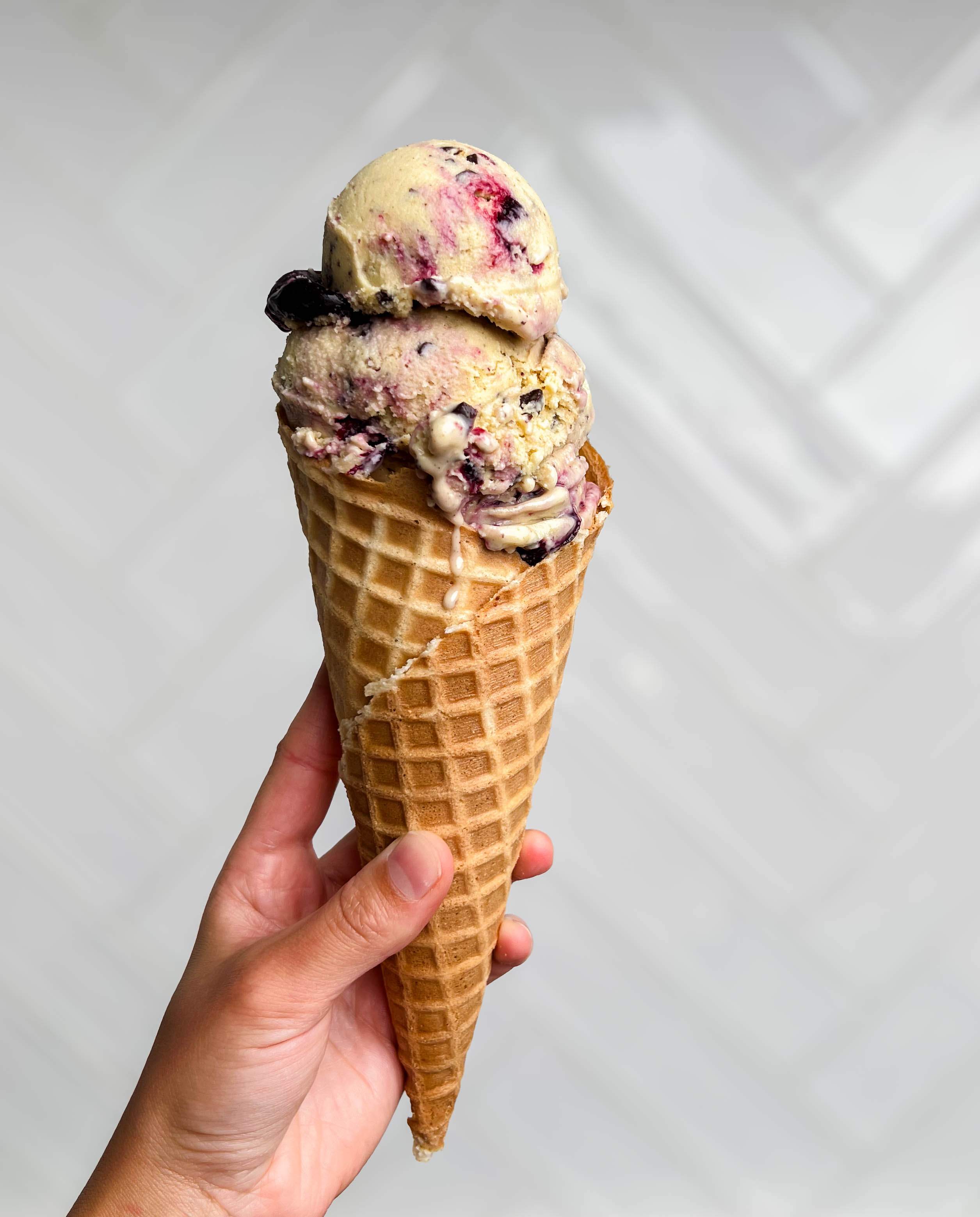 cherry vanilla ice cream in a waffle cone