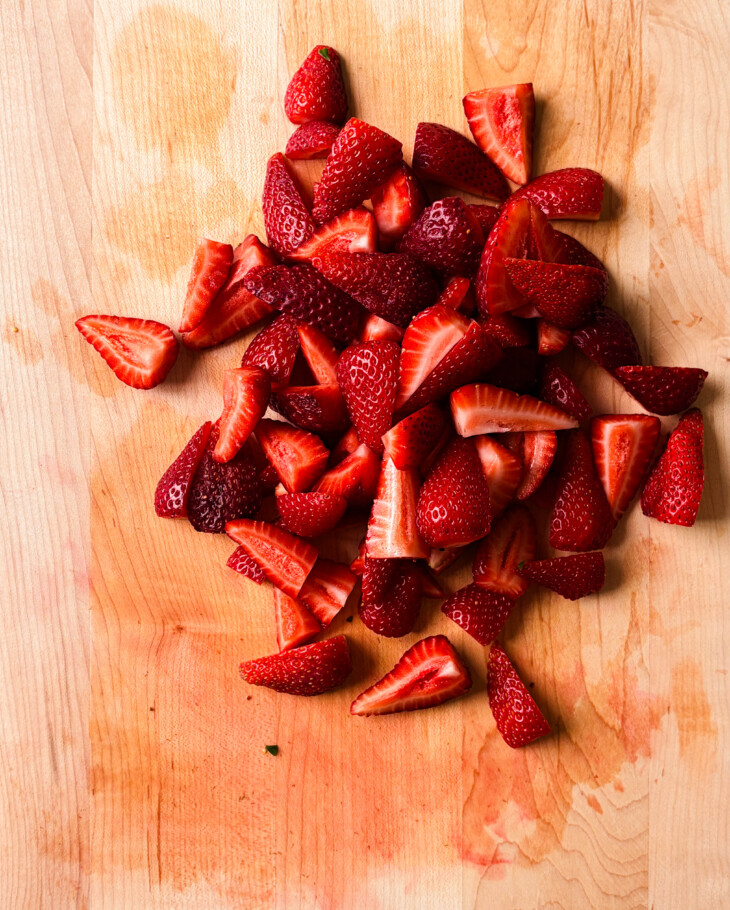 sliced strawberries on a wooden cutting board